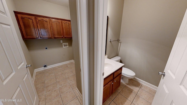 half bathroom with tile patterned floors, toilet, baseboards, and vanity