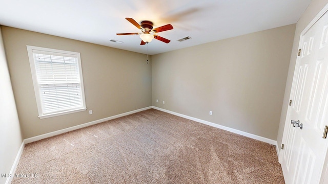 unfurnished room featuring ceiling fan, visible vents, and carpet
