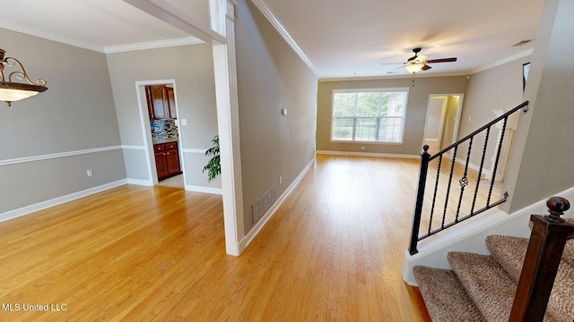 entrance foyer with crown molding, light wood-type flooring, and ceiling fan