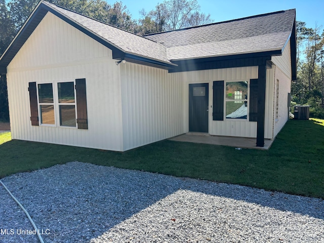 view of front of home with cooling unit and a front yard