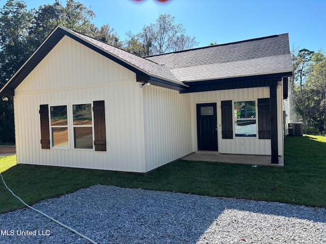 view of front of property with central AC and a front lawn