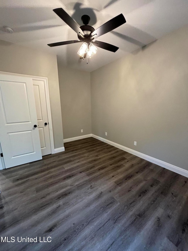 unfurnished room featuring dark wood-type flooring and ceiling fan