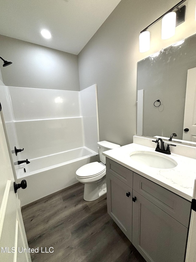 full bathroom with shower / bathing tub combination, hardwood / wood-style floors, vanity, and toilet