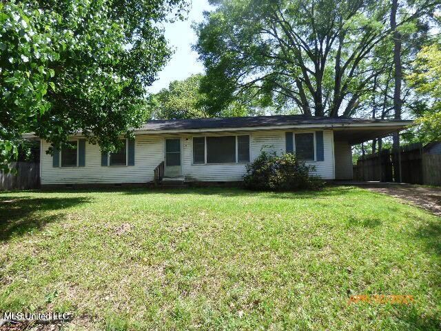 ranch-style home featuring crawl space, fence, a front yard, and an attached carport