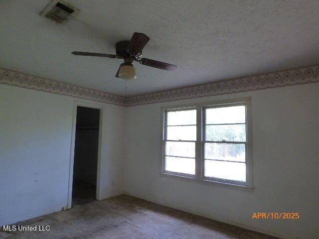 interior space featuring visible vents, carpet flooring, ceiling fan, and a closet