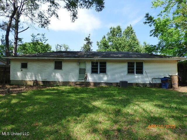 rear view of property featuring a yard, cooling unit, and entry steps