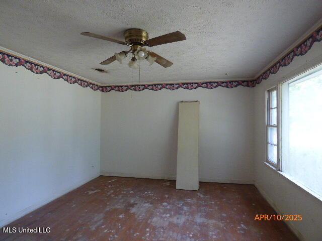 unfurnished room with a ceiling fan, a textured ceiling, and visible vents