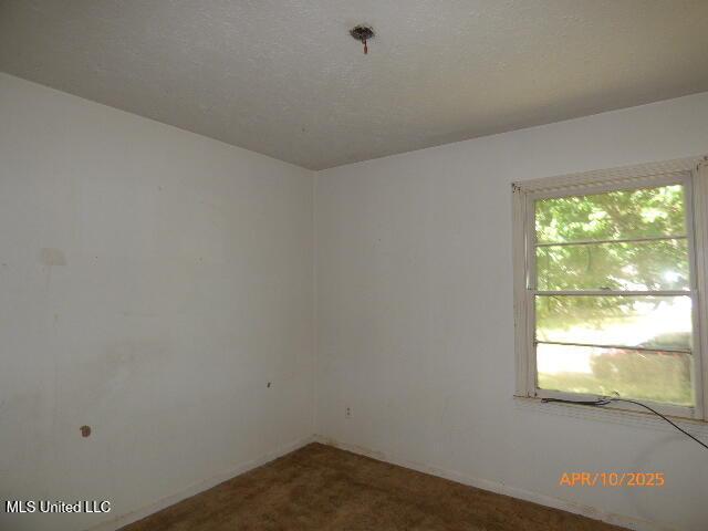 carpeted spare room with baseboards