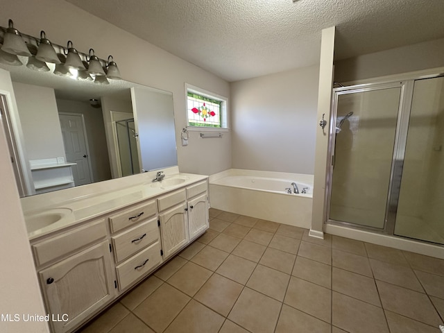 bathroom featuring a garden tub, double vanity, a sink, a shower stall, and tile patterned floors