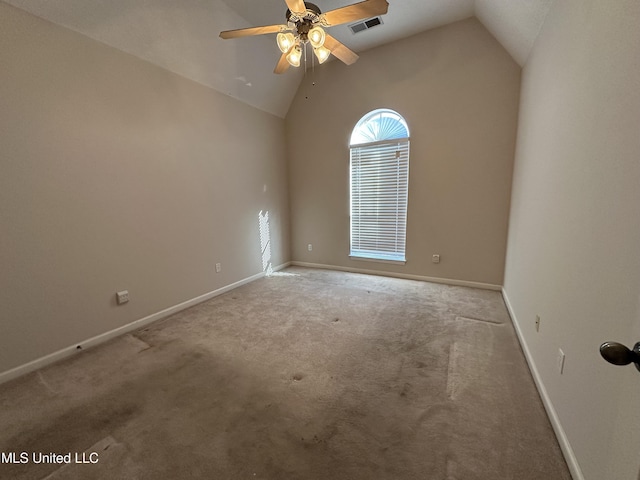 carpeted empty room with lofted ceiling, a ceiling fan, visible vents, and baseboards