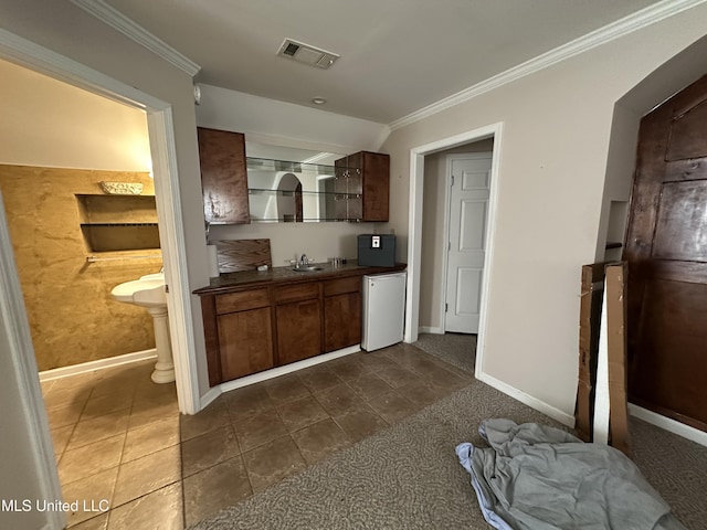 interior space featuring dark countertops, visible vents, ornamental molding, a sink, and dishwasher