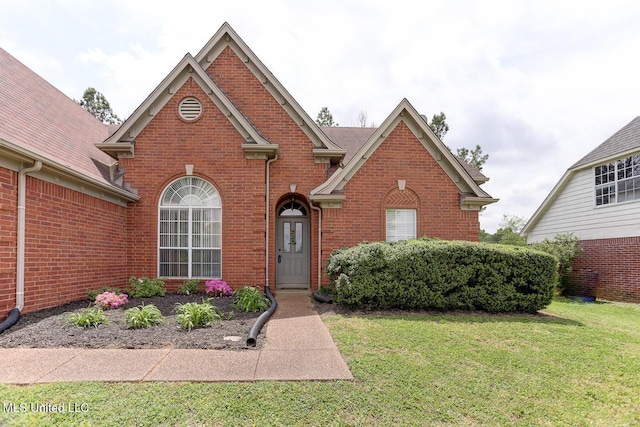 traditional home featuring a front lawn and brick siding