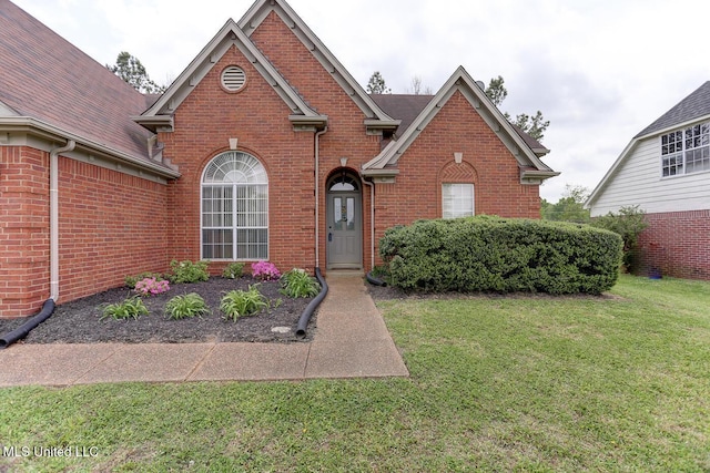 traditional-style house featuring a front lawn and brick siding
