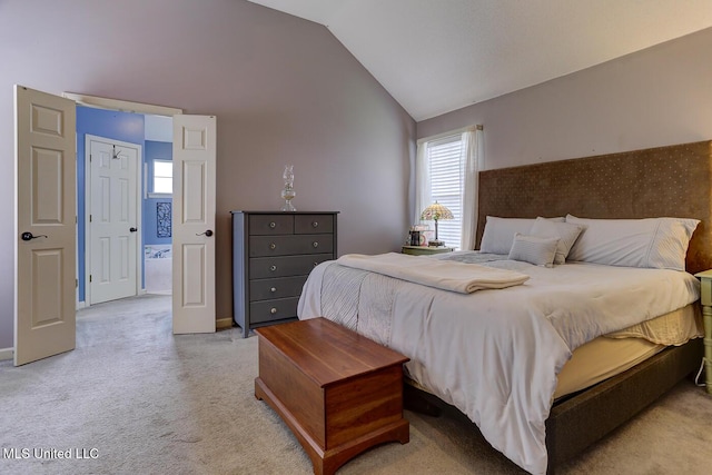 bedroom with light colored carpet, vaulted ceiling, and baseboards