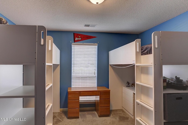unfurnished bedroom with visible vents, carpet, and a textured ceiling
