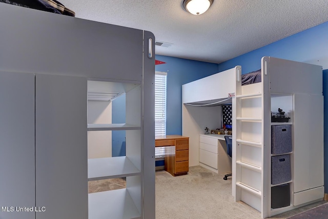 bedroom featuring a textured ceiling, visible vents, and carpet