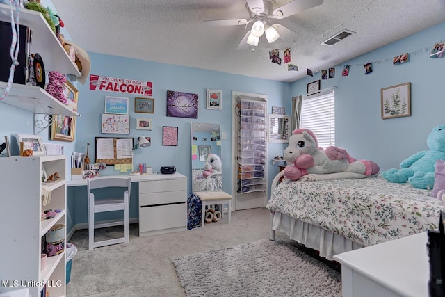 bedroom featuring a ceiling fan, visible vents, carpet floors, and a textured ceiling