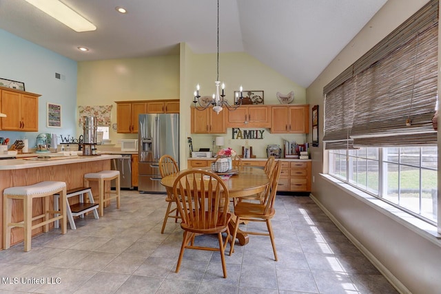 dining room featuring high vaulted ceiling, light tile patterned flooring, an inviting chandelier, baseboards, and visible vents