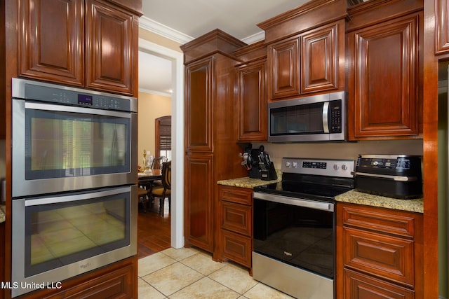 48 Harrell Rd, Hattiesburg, MS 39401 - kitchen featuring stainless steel appliances, ornamental molding, light tile patterned floors, and light stone counters