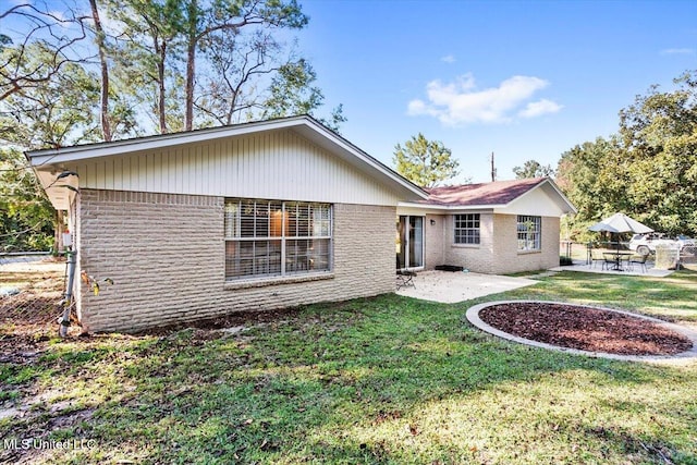 back of property featuring a patio and a yard