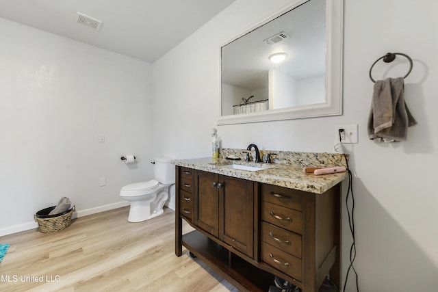 bathroom with vanity, wood-type flooring, and toilet