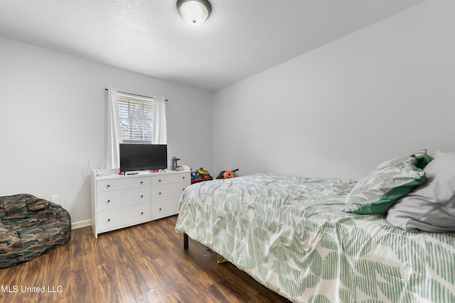 bedroom with dark hardwood / wood-style floors