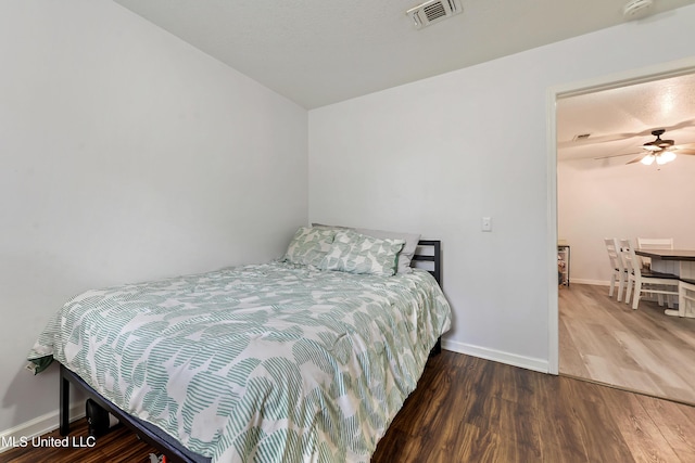 bedroom with dark hardwood / wood-style floors