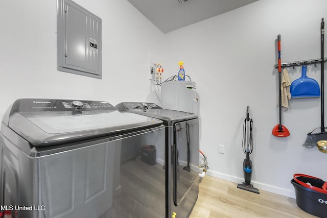 laundry room featuring electric water heater, electric panel, washer and clothes dryer, and light wood-type flooring