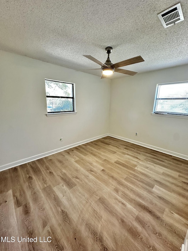 809 Herrick Ave, Pascagoula, MS 39567 - spare room featuring healthy amount of natural light, a textured ceiling, wood finished floors, and a ceiling fan