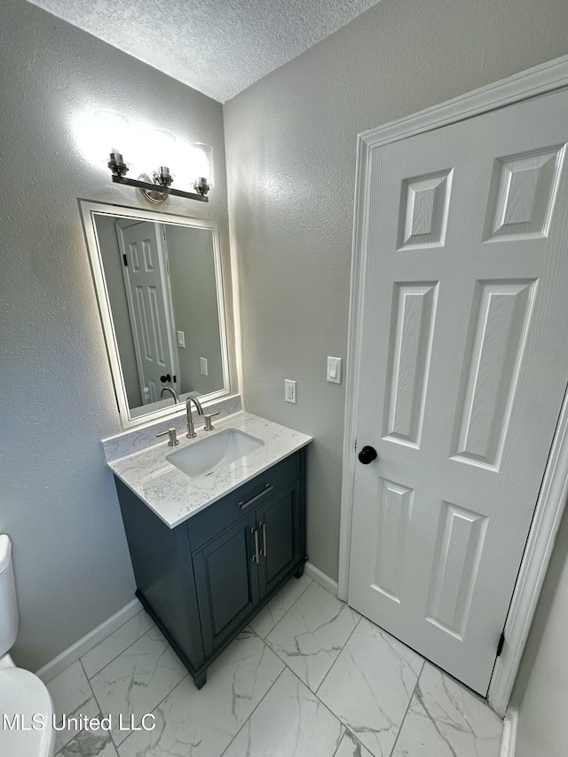 809 Herrick Ave, Pascagoula, MS 39567 - bathroom featuring marble look tiles, vanity, and a textured ceiling