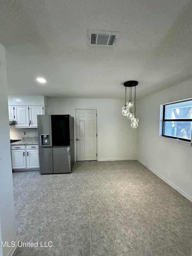 809 Herrick Ave, Pascagoula, MS 39567 - kitchen featuring stainless steel fridge with ice dispenser, white cabinetry, backsplash, a textured ceiling, and light tile patterned floors