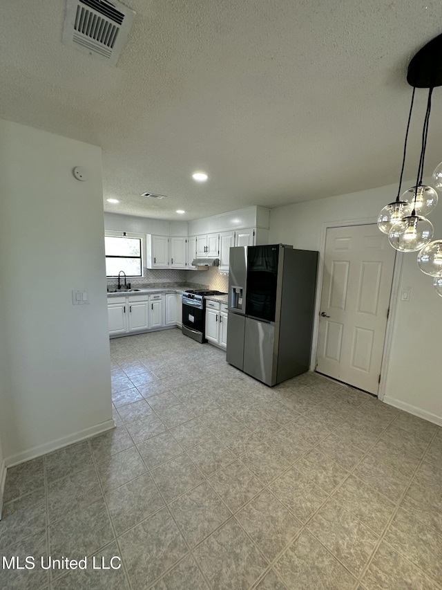 809 Herrick Ave, Pascagoula, MS 39567 - kitchen featuring appliances with stainless steel finishes, under cabinet range hood, a chandelier, a textured ceiling, and white cabinets