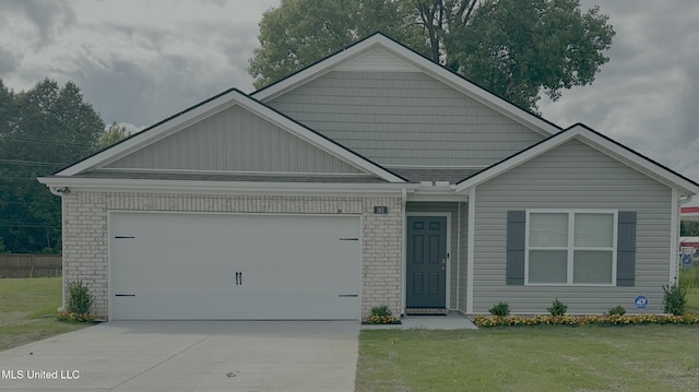 57 Silo Ln, Byhalia, MS 38611 - view of front of house with an attached garage, concrete driveway, a front yard, and brick siding