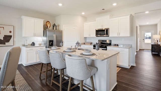 57 Silo Ln, Byhalia, MS 38611 - kitchen featuring appliances with stainless steel finishes, a sink, a breakfast bar, white cabinetry, and an island with sink