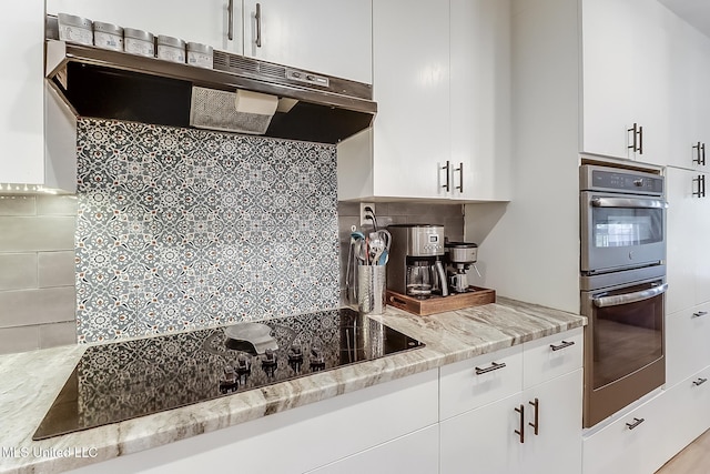 129 Marcie Dr, Long Beach, MS 39560 - kitchen with ventilation hood, stainless steel double oven, backsplash, black electric cooktop, and white cabinets