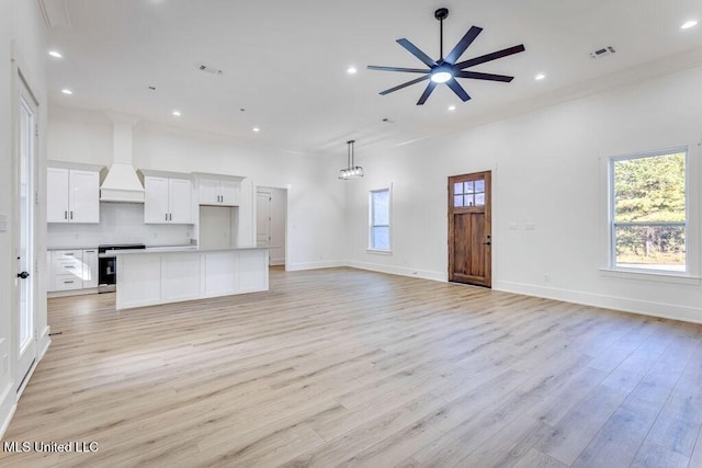 unfurnished living room featuring ceiling fan and light wood-type flooring