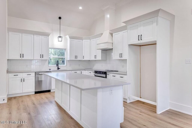 kitchen with stainless steel appliances, sink, decorative light fixtures, white cabinets, and a kitchen island