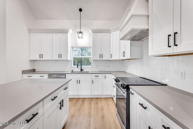 kitchen featuring premium range hood, pendant lighting, white cabinetry, range with electric cooktop, and sink