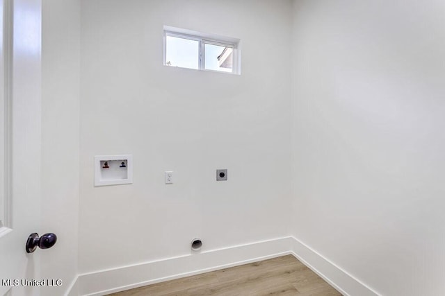 clothes washing area with hookup for a washing machine, hookup for an electric dryer, and light hardwood / wood-style flooring