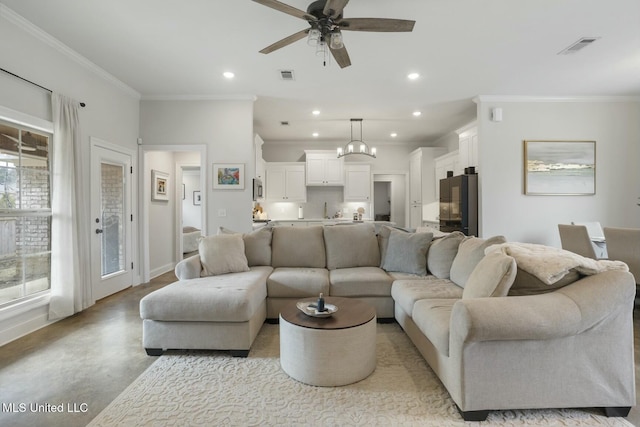 living room with ceiling fan with notable chandelier, sink, and crown molding