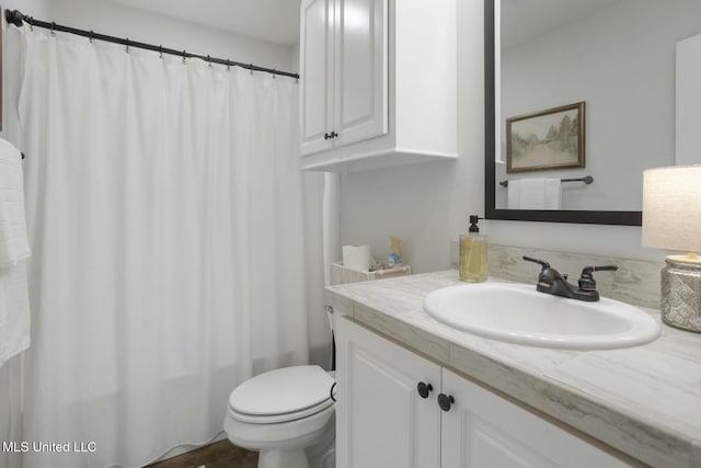 bathroom with a shower with shower curtain, vanity, and toilet