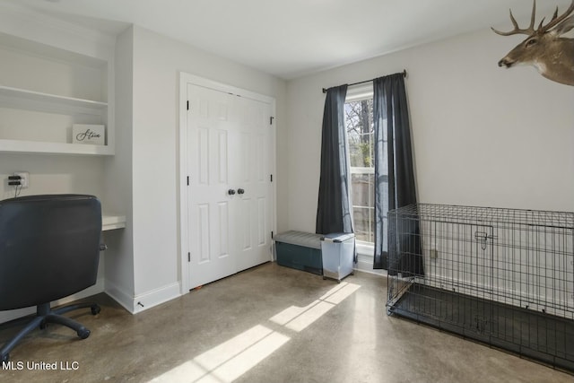 office area featuring built in features and concrete flooring