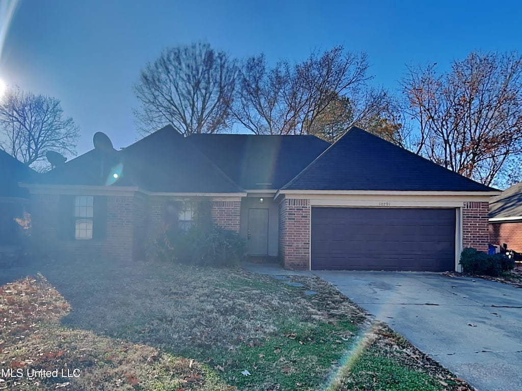 single story home featuring a garage, concrete driveway, and brick siding