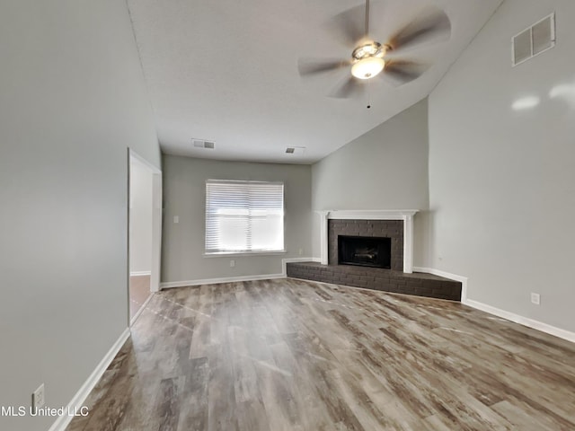 unfurnished living room featuring wood finished floors, a fireplace, visible vents, and ceiling fan