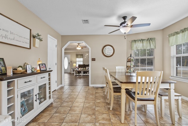 tiled dining space featuring ceiling fan and a textured ceiling