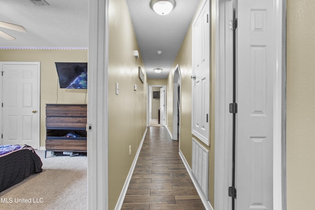 corridor featuring dark hardwood / wood-style floors and a textured ceiling