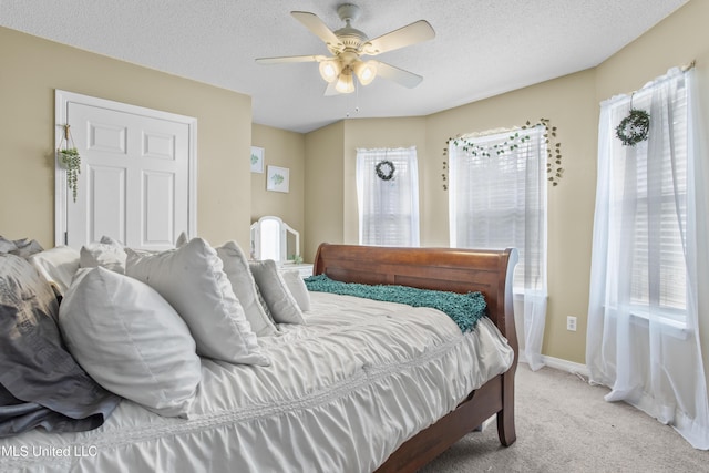 bedroom featuring multiple windows, light carpet, and a textured ceiling