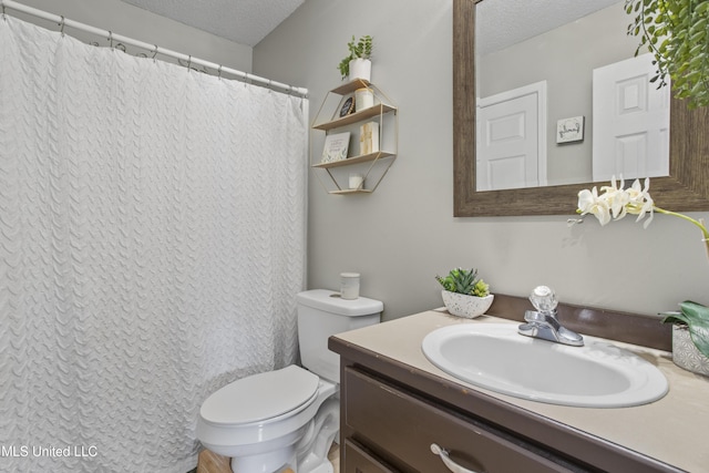 bathroom featuring vanity, toilet, and a textured ceiling