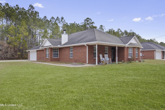 rear view of house with a porch, a garage, and a yard