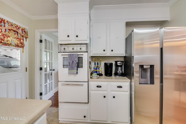 kitchen with white cabinets, crown molding, double oven, and stainless steel refrigerator with ice dispenser